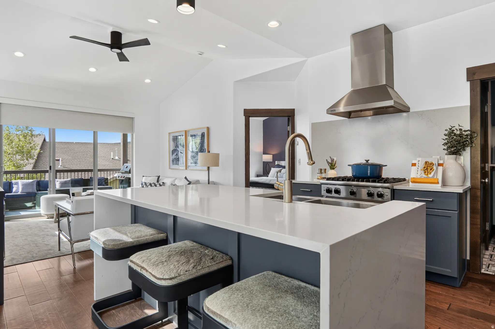 Vaulted ceilings, wood-finish flooring, recessed lighting, white countertops, and stainless steel appliances