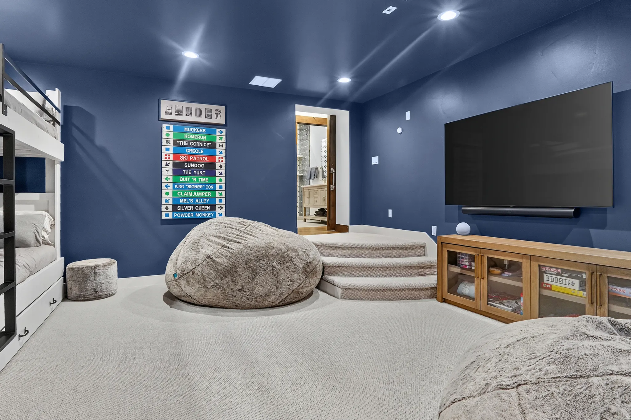 Integrated bunk beds, recessed lighting, wall-mounted television, and a built-in media console