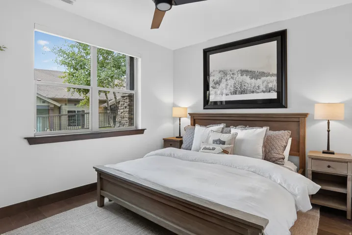 Wood-finish flooring, white walls, and a large window with dark wood trim