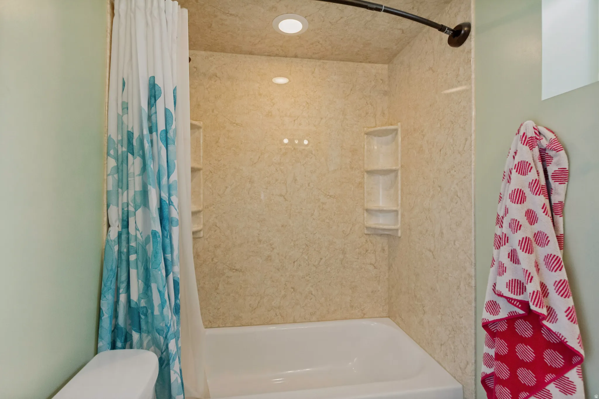 Updated Master Bath featuring a spacious walk-in shower with textured tile surround, recessed lighting, built-in shower niche, and a bathtub with coordinating tile enclosure and overhead rainfall showerhead