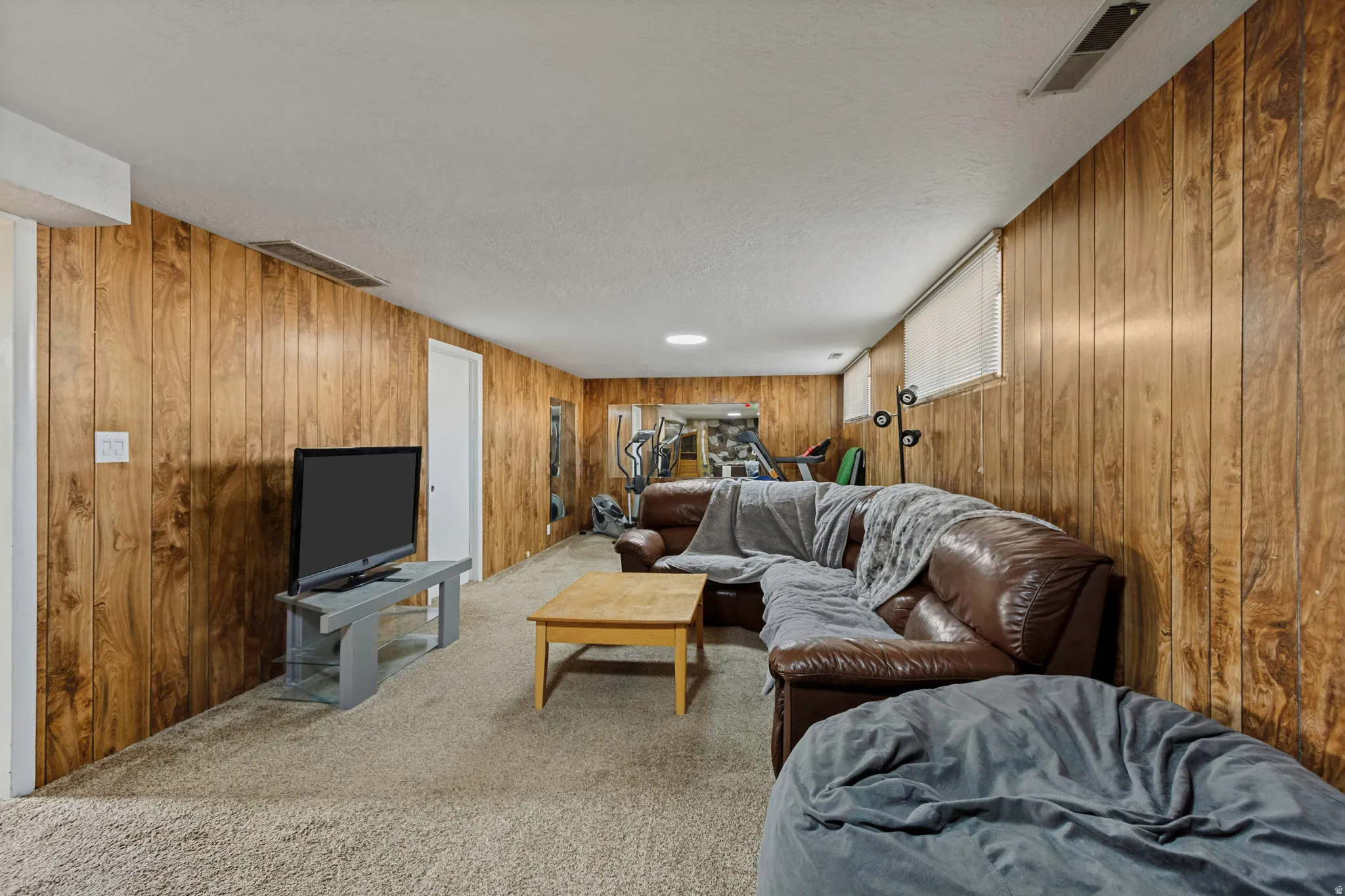 Carpeted floor, wood-paneled walls, and recessed lighting