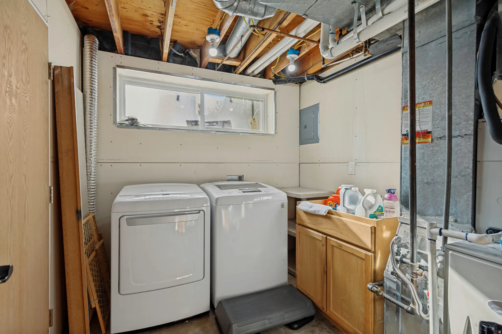 Utility area with a built-in wood-finish cabinet and an exposed ceiling