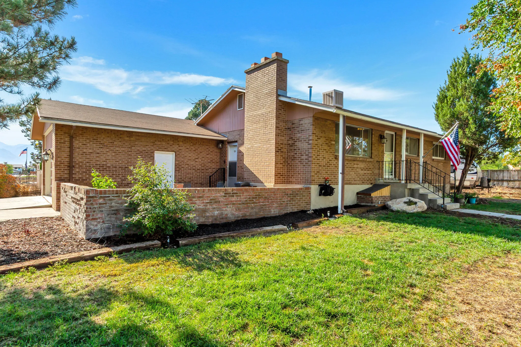 Brick exterior with a covered porch entry, chimney, and an attached garage