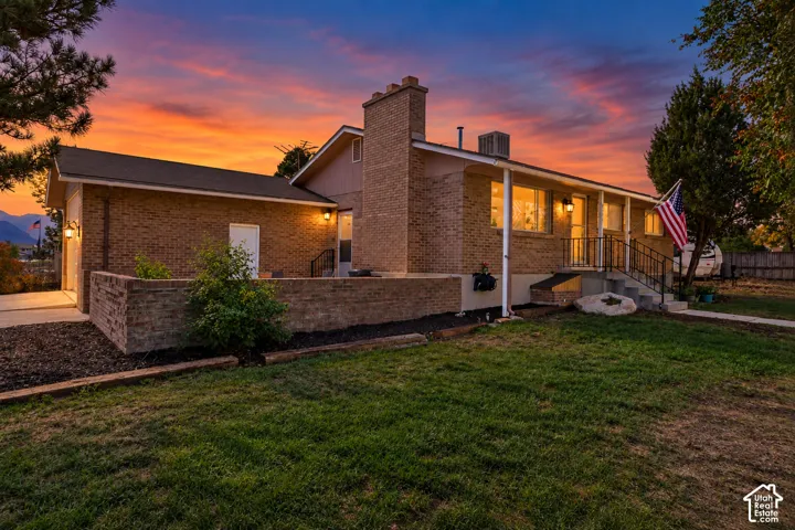 Brick exterior architecture with an attached garage, covered front porch, and a dedicated patio area