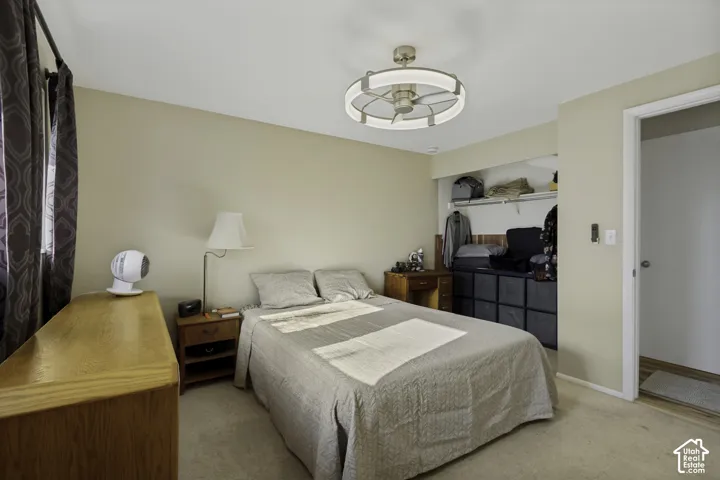 Wall-to-wall carpeting with neutral wall tones, featuring a ceiling fan with integrated lighting