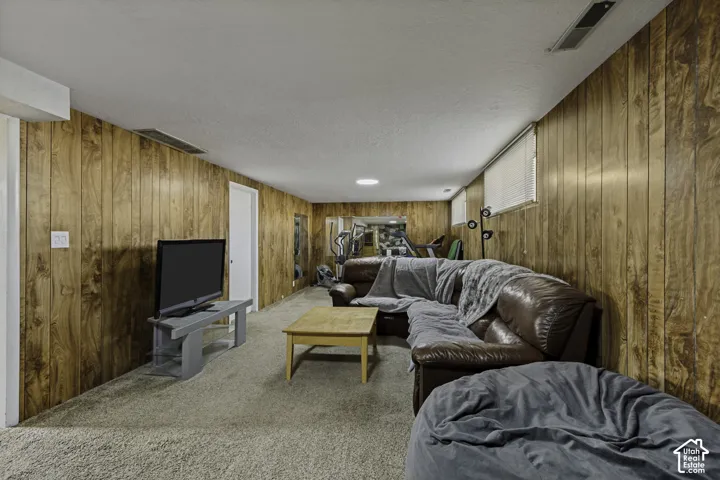 Carpeted floor, wood-paneled walls, and recessed lighting