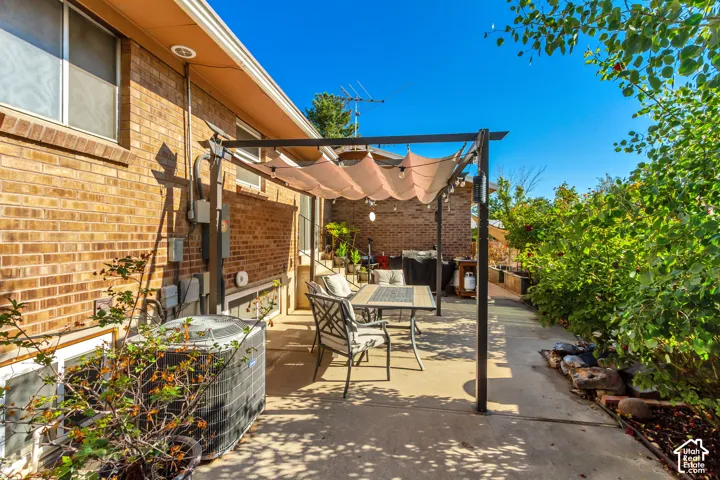 Brick exterior with a covered patio area and mature landscaping