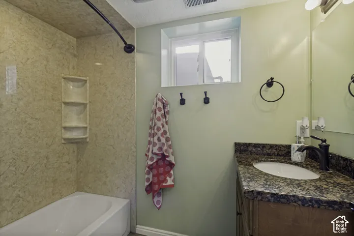 Built-in bathtub with shower, integrated shelving, and a curved shower rod