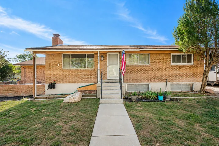 Brick exterior residence featuring a front walkway, concrete steps, and a covered entry