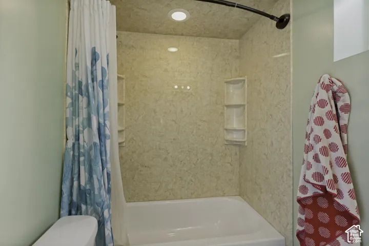 Updated Master Bath featuring a spacious walk-in shower with textured tile surround, recessed lighting, built-in shower niche, and a bathtub with coordinating tile enclosure and overhead rainfall showerhead