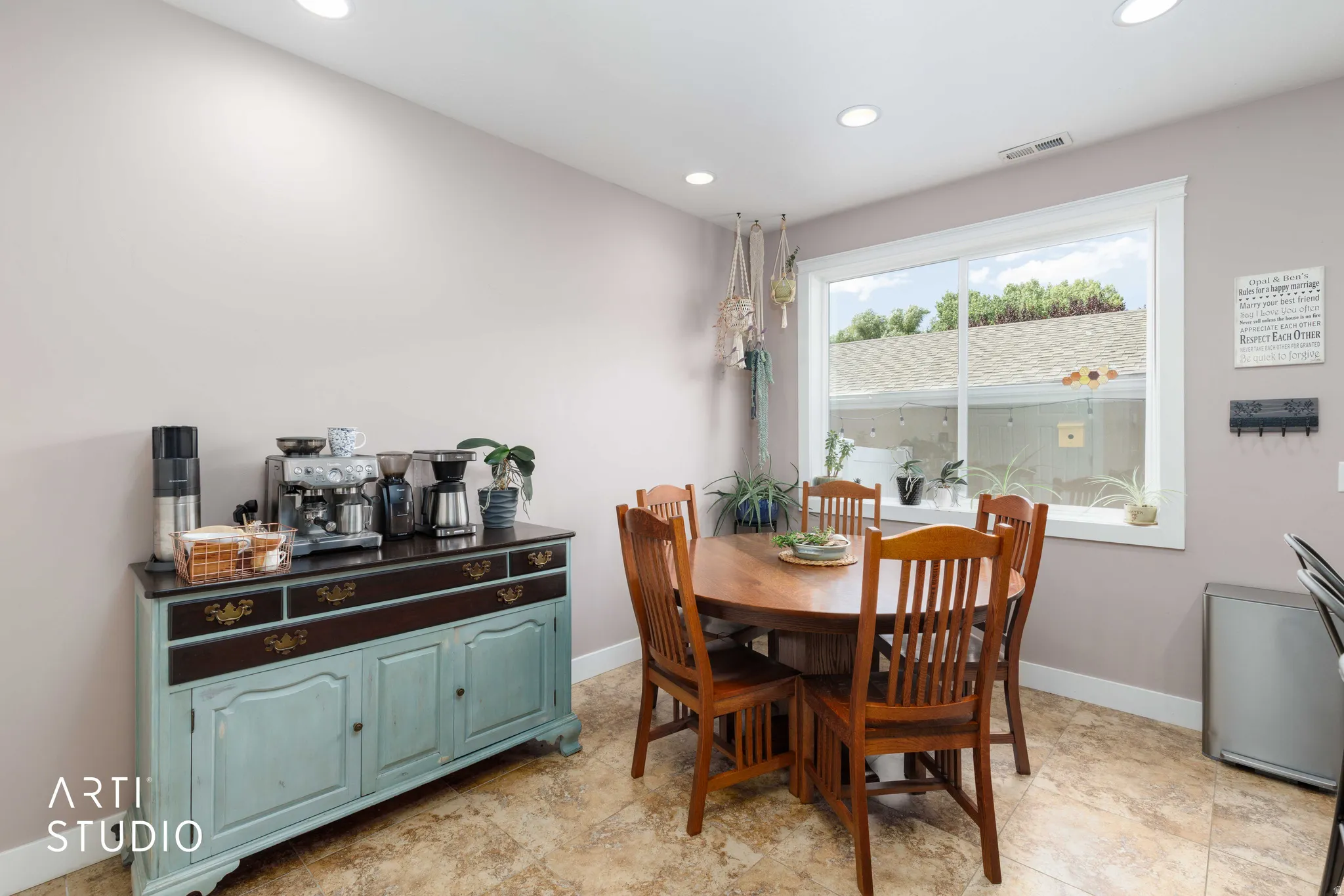 Recessed lighting, large window with white trim, tan tiled flooring, and light gray walls