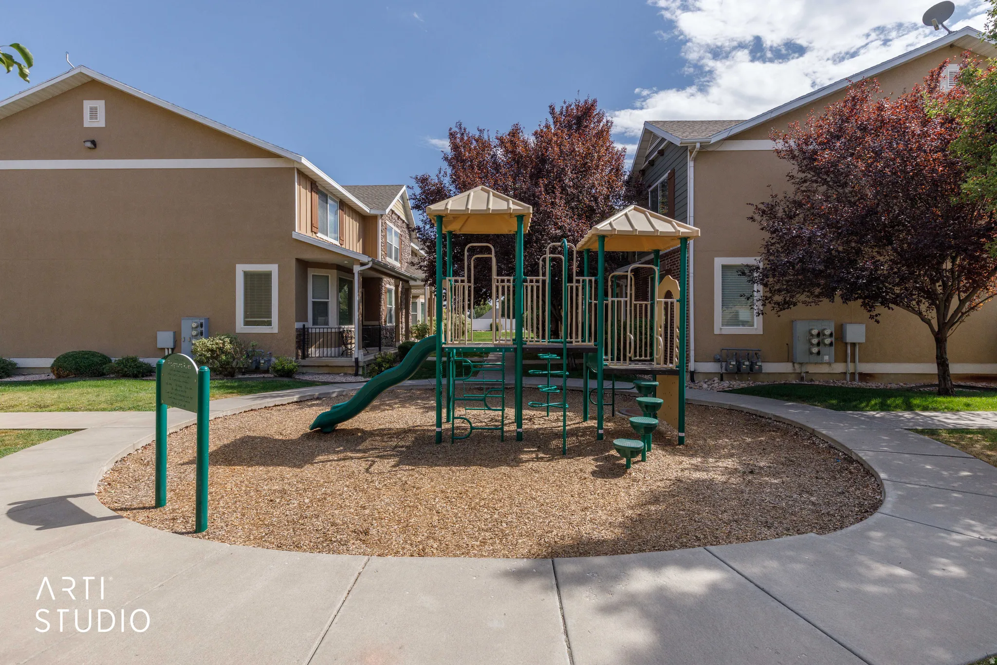 Community playground featuring a slide, climbing structure, and wood chip base