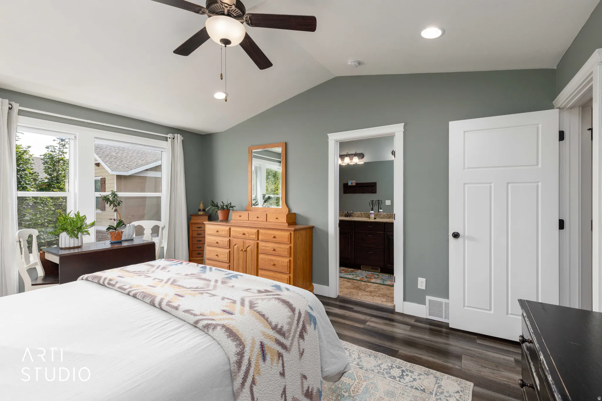 Vaulted ceiling with a ceiling fan, recessed lighting, wood-finish flooring, and a panel door