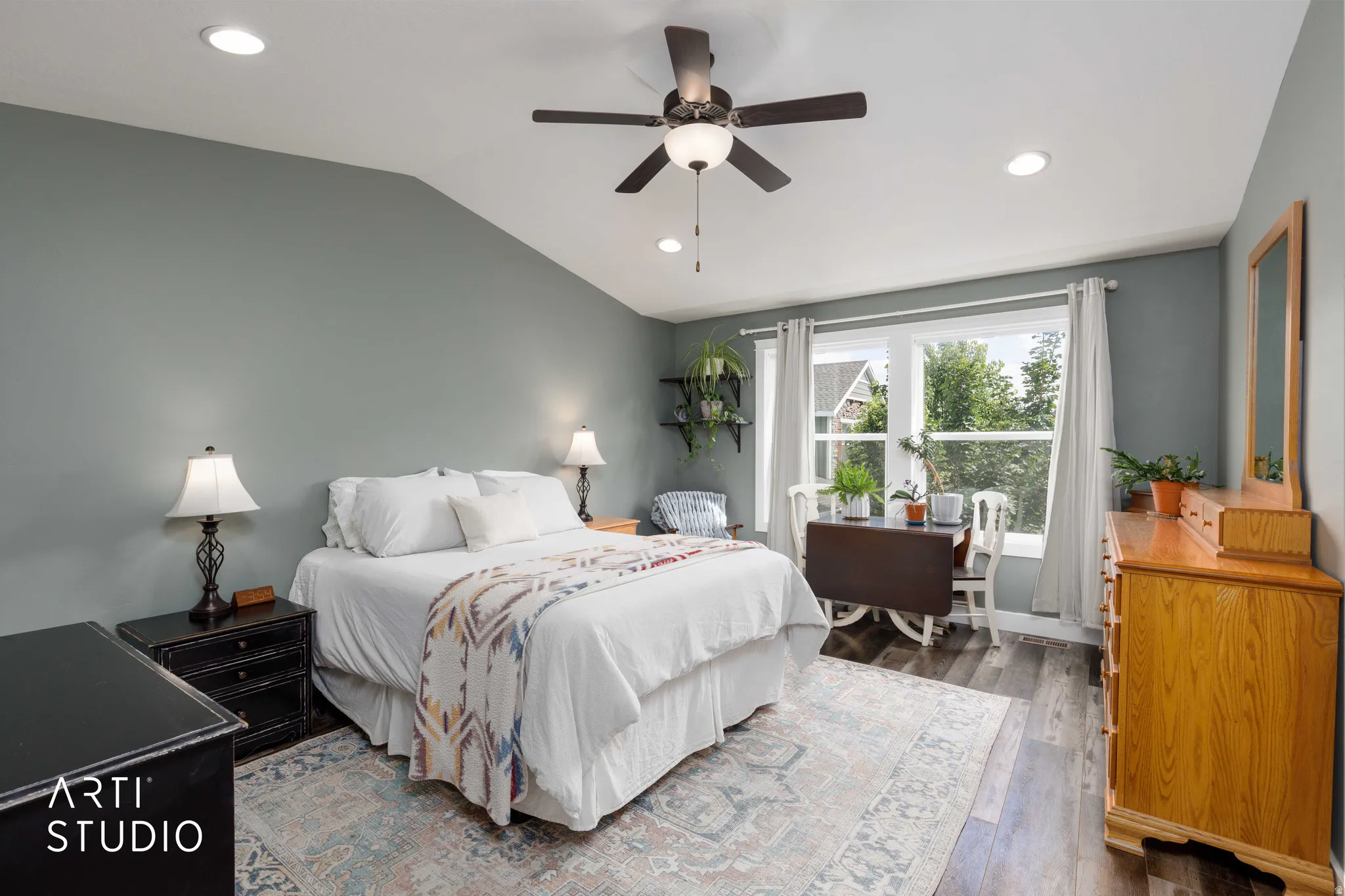 Primary bedroom suite featuring soft sage-green walls, recessed ceiling lighting, and a ceiling fan with integrated light fixture