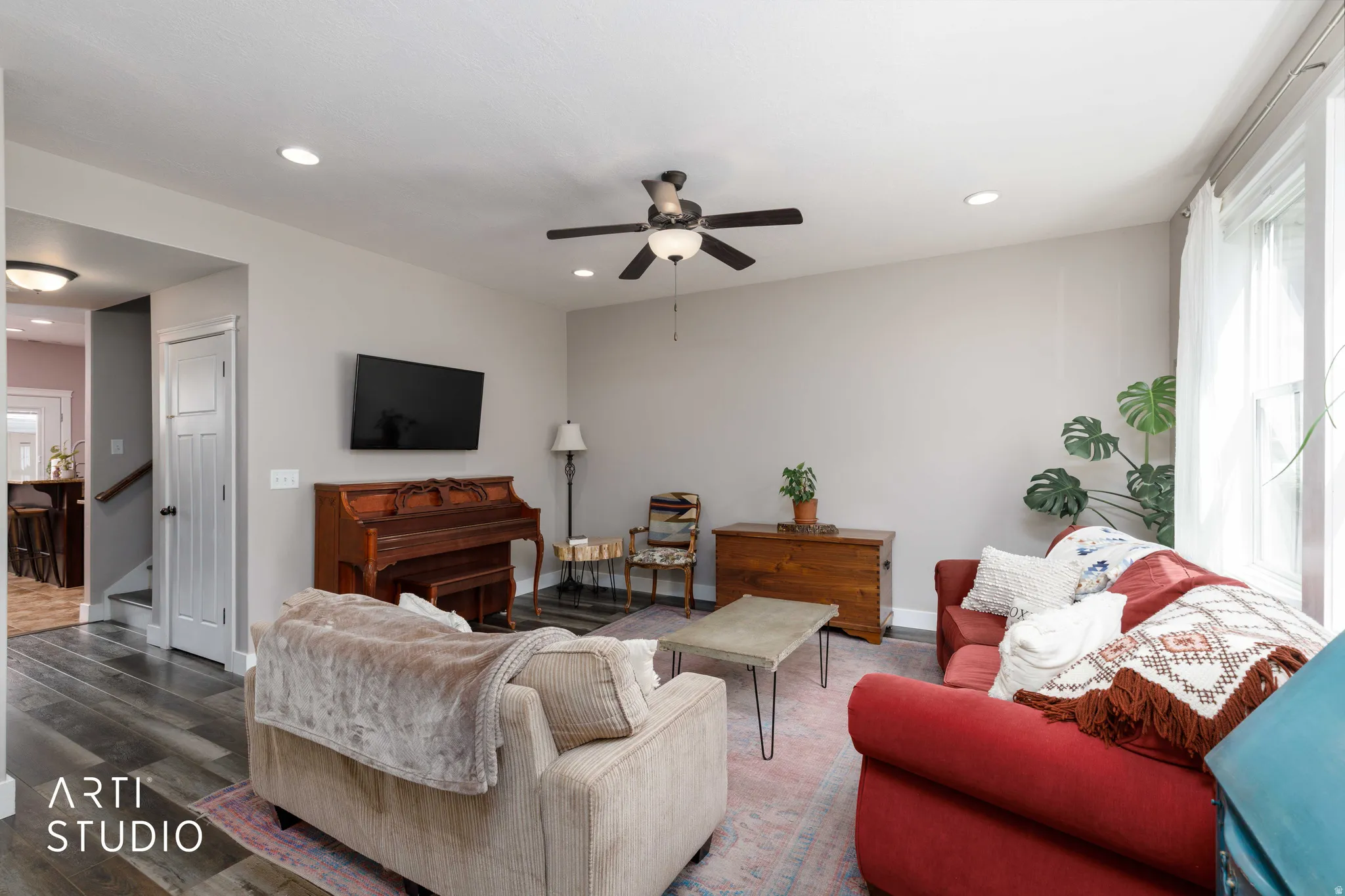 Living area with wood-finish flooring, recessed lighting, and a ceiling fan