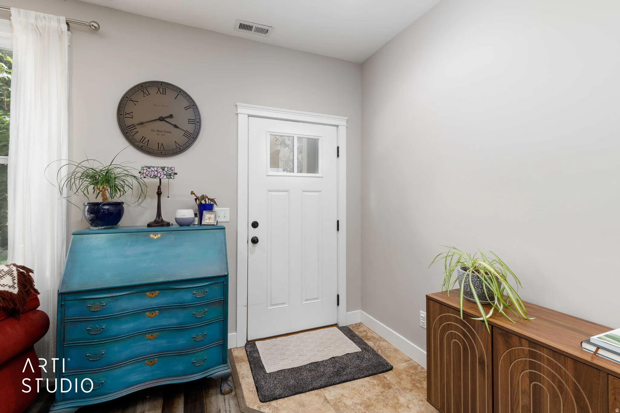Entryway with a white paneled door featuring a window insert and dark hardware