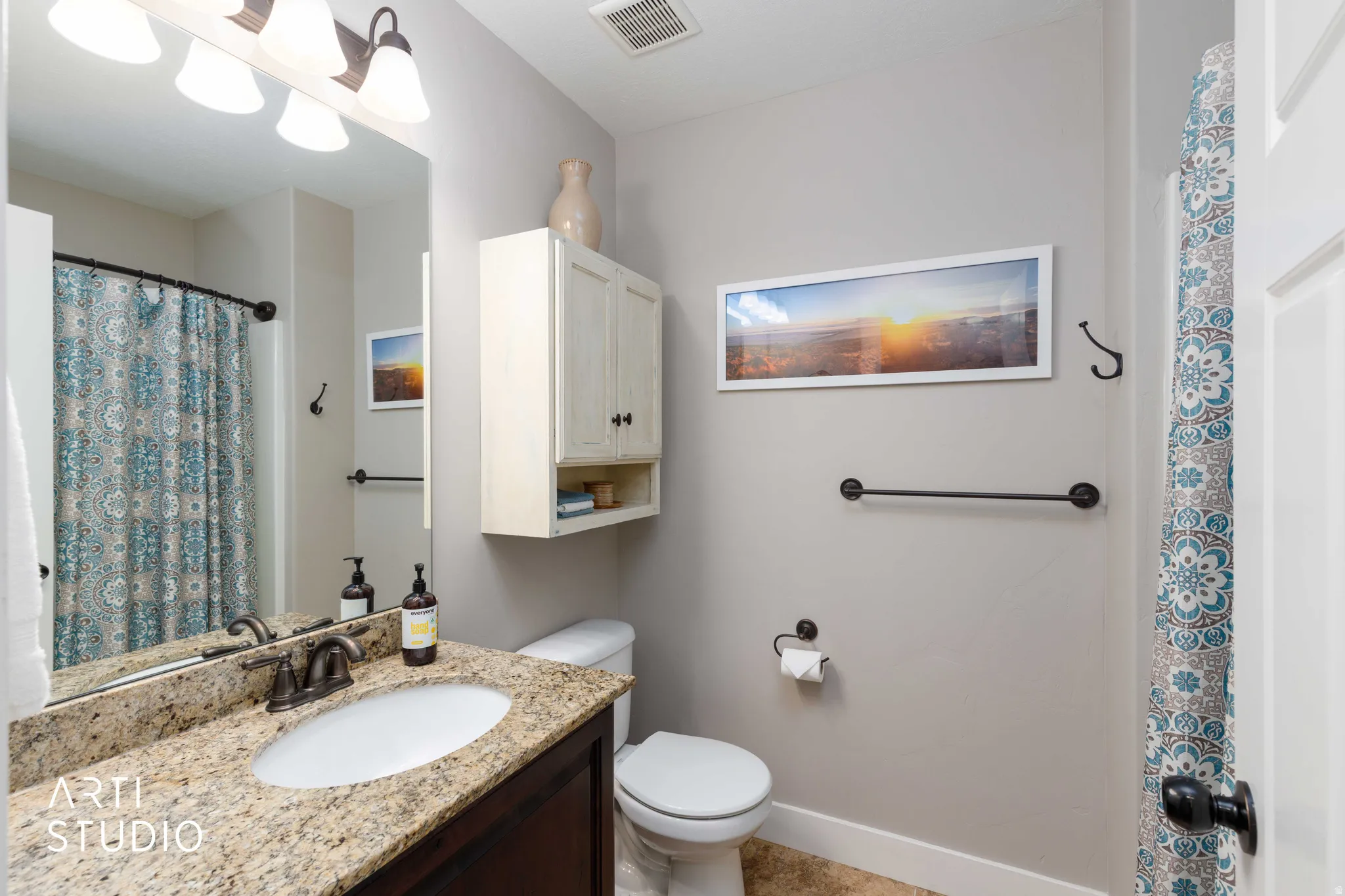 Vanity with a granite-style countertop, undermount sink, and bronze-finish faucet