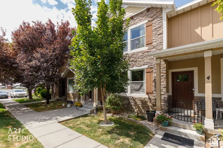Stone veneer exterior with decorative window shutters and a covered entry