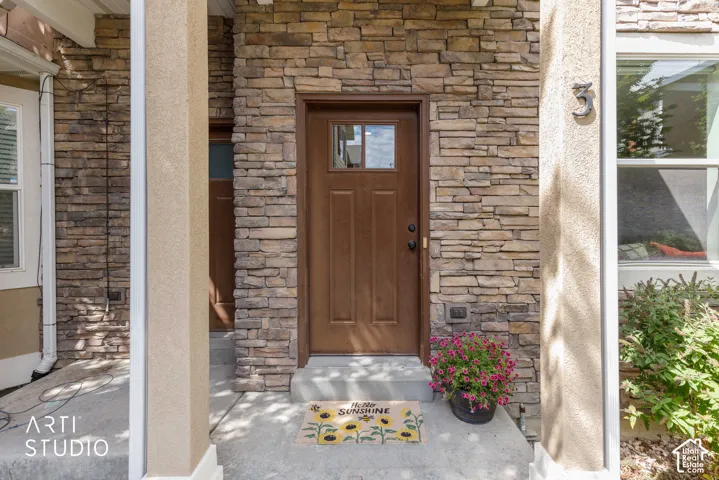 Stone veneer exterior with a brown entry door featuring divided lites