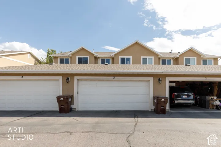 Multi-unit property with a stucco exterior, multiple attached garages, and individual lighting fixtures