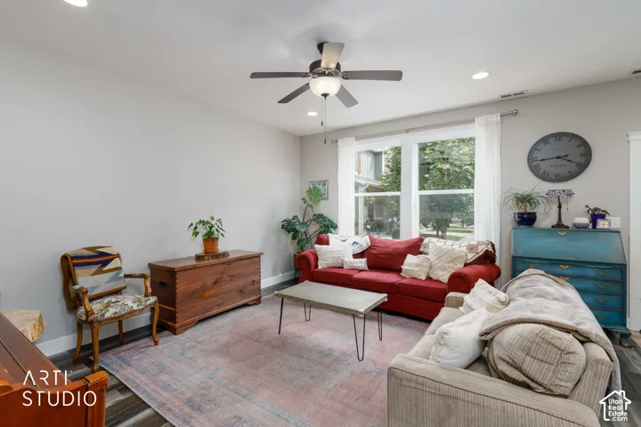 Recessed lighting, ceiling fan with integrated light, large windows, and dark wood-finish flooring