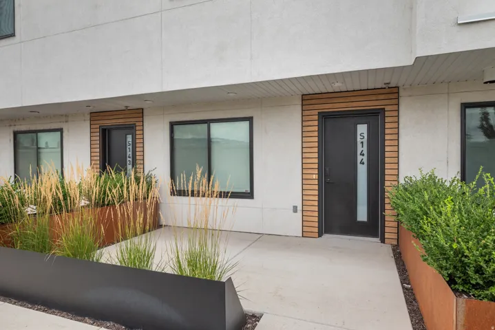 Modern exterior with a contrasting wood-panel accent wall framing the entry door