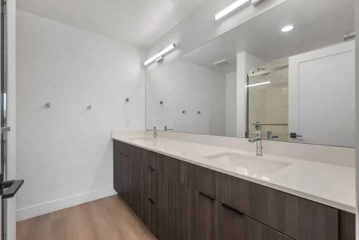 Dual vanity with integrated sinks, quartz countertop, and wood-finish cabinetry