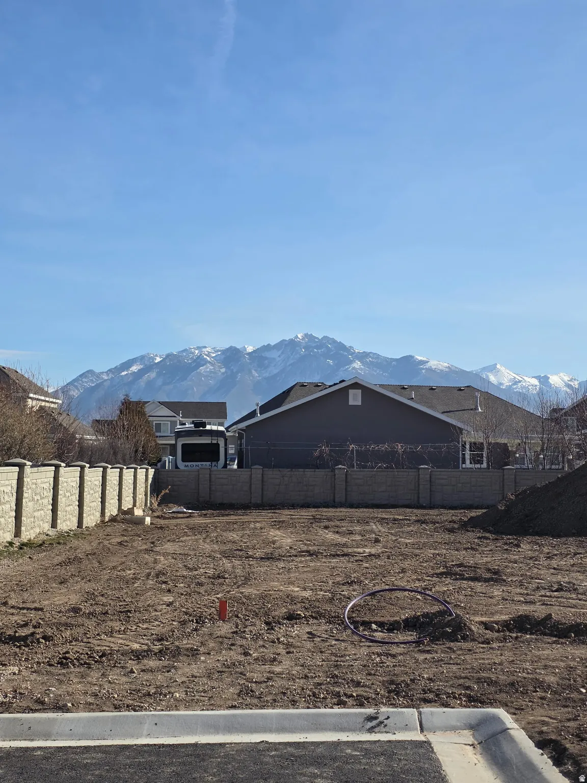 Cleared lot with a concrete perimeter, featuring a block wall boundary