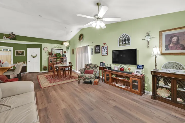 Vaulted ceilings, wood-finish flooring, ceiling fan, and sliding glass door