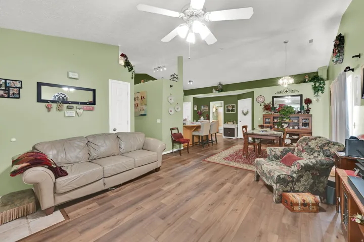 Vaulted ceiling with a ceiling fan, wood-finish flooring, and recessed lighting