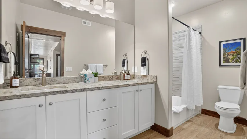 Dual vanity with white cabinetry and granite countertops