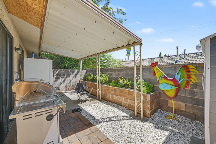 Covered patio area featuring a metal awning and brick paver flooring