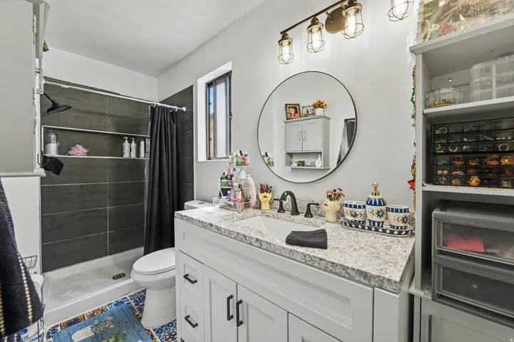White vanity with a speckled countertop, undermount sink, and matte black faucet