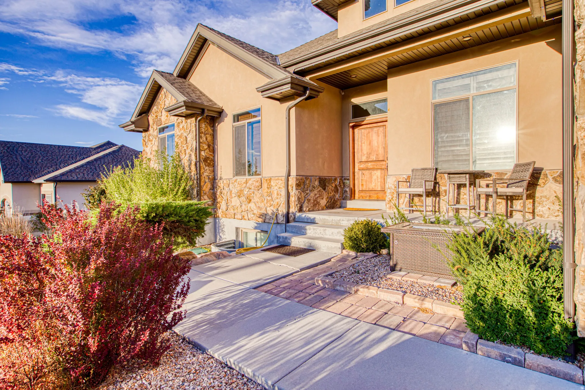 Stucco exterior with stone accents, a prominent front entry, and multiple windows