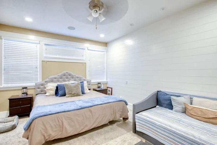 Recessed lighting, ceiling fan, white shiplap accent wall, and multiple windows with blinds