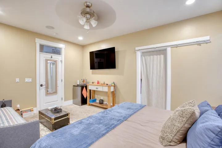 Recessed lighting, ceiling fan with light fixture, mounted television, and a built-in speaker