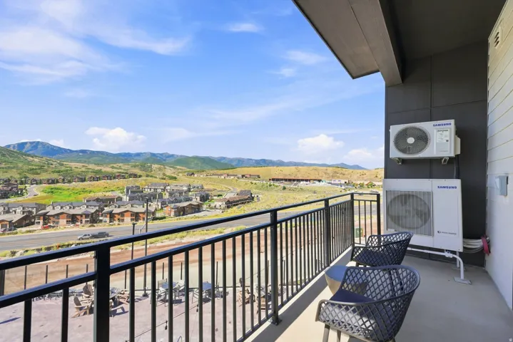Expansive balcony with metal railing offering panoramic vistas of rolling hills and valley landscape