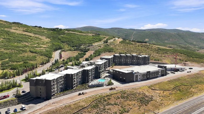 Modern multi-story buildings featuring balconies and a central outdoor swimming pool