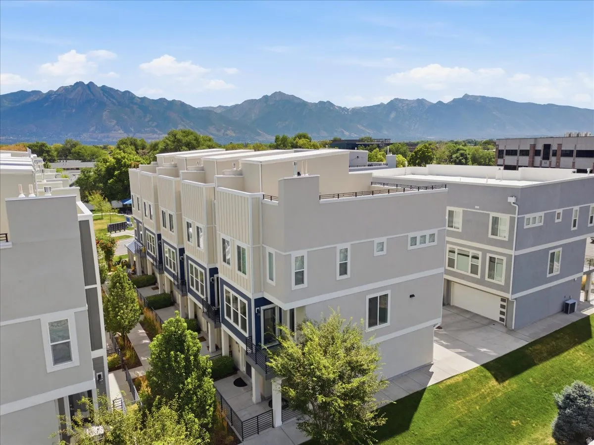 Contemporary townhome architecture with a flat roofline, multi-pane windows, and a prominent mountain backdrop