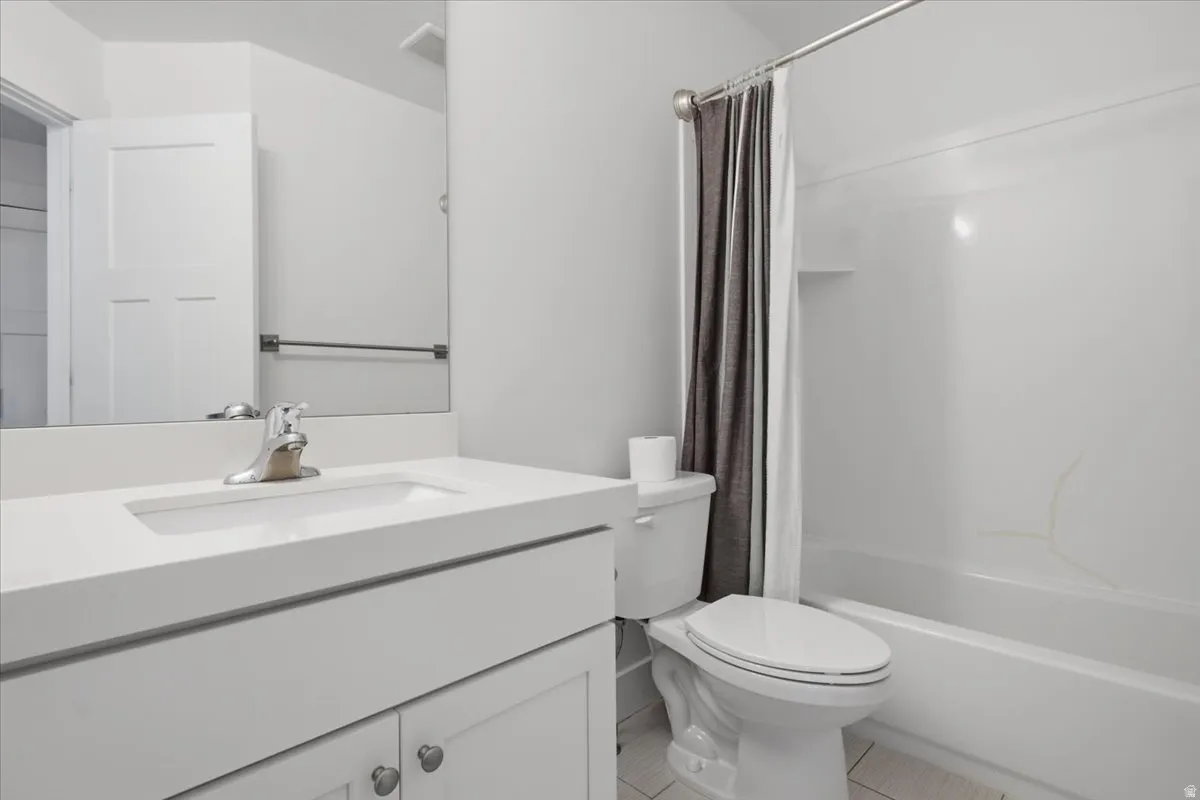 Integrated white vanity sink with chrome faucet, white paneled cabinetry, and a full-width mirror