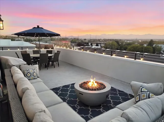 Rooftop deck featuring a fire pit, string lights, and a full perimeter railing