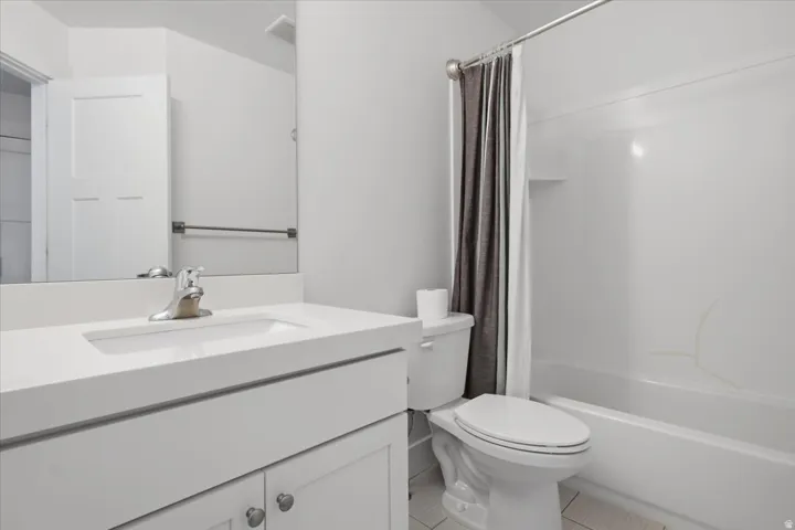 Integrated white vanity sink with chrome faucet, white paneled cabinetry, and a full-width mirror