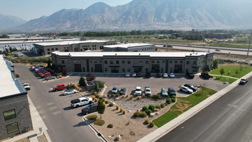 Multi-unit commercial building featuring dark gray exterior siding and large garage doors