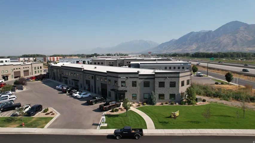 Modern commercial building with a black and gray facade, multiple windows, and a curved architectural element