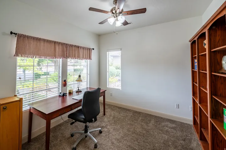 Vaulted ceilings, a built-in wood-finish bookcase, and carpeted flooring