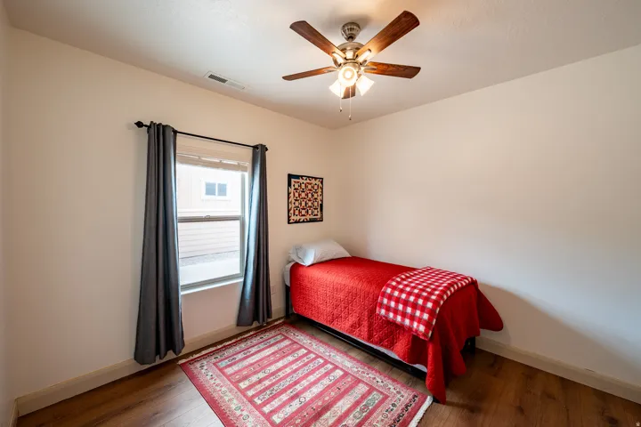 Recessed window with natural light, wood-finish flooring, and a ceiling fan with integrated lighting