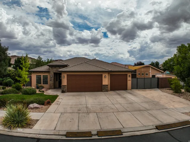 Stucco exterior with stone accents, tile roofing, and a dual garage