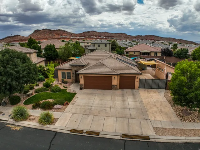 Stucco exterior with stone accents, tile roofing, and a two-car garage
