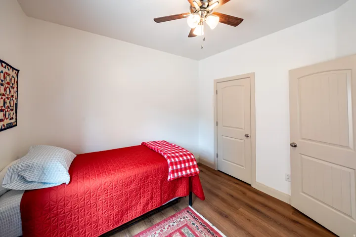 Wood-finish flooring, ceiling fan with integrated lighting, and neutral wall tones
