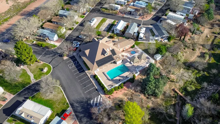 Community building with a pitched roof, outdoor swimming pool, and dedicated parking spaces